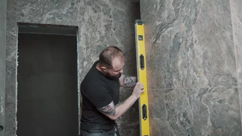 Man working on wall tile installation with a level tool Video stock 307041877