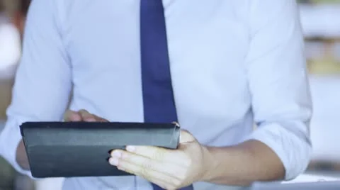 Man working in a warehouse is working on a digital tablet and checking inventory Stock Footage 13741540