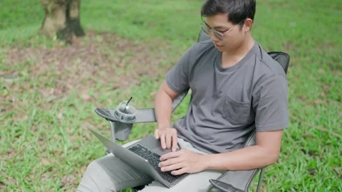 Man working while on vacation, freelancer at laptop while sitting in nature. Stock Footage 283186400