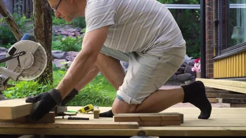 Man working on wooden deck construction outdoors Stock Footage 307384002