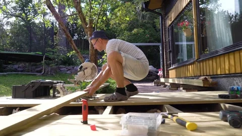 Man working on wooden deck construction outdoors Stock Footage 307385284
