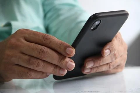 Man working in workplace on mobile in hands Stock Photos