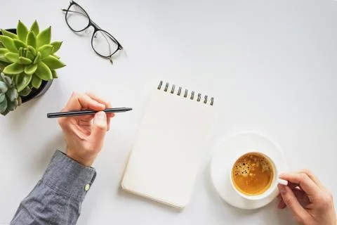 Man working writing in the notepad and drinking coffee Stock Photos
