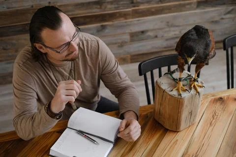 Man is working, writing with wild eagle bird Top view Stock Photos