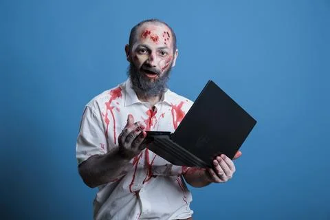 Man working like zombie, inputting data on notebook, studio background Stock Photos