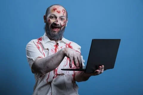 Man working like zombie, inputting data on notebook, studio background Stock Photos