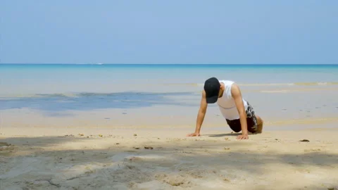Man workout by  push up at the sandy beach, part of his cross fitness workout. Stock Footage 133227275