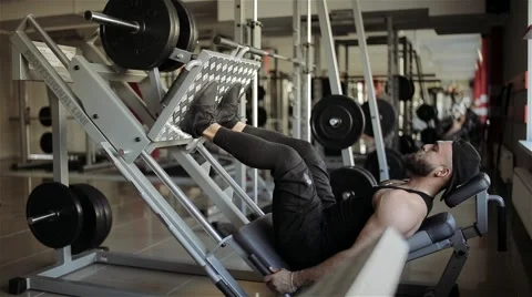 Man workout with simulator leg press in the gym Stock Footage 56635802