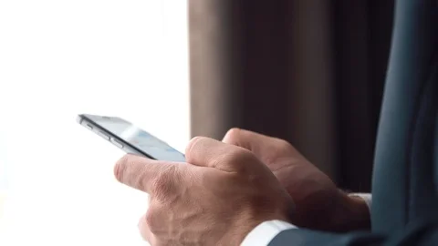 Man in the workplace using his smartphone, checking financial reports Stock Footage 123916351