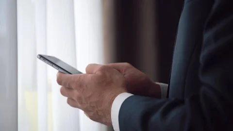 Man in the workplace using his smartphone, tapping on screen Stock Footage 123916353