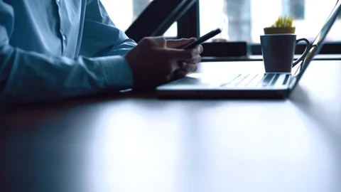 Man in the workplace using his smartphone, scrolling news Stock Footage 123916382