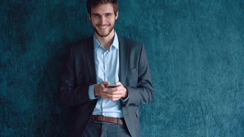Man in the workplace using his smartphone, scrolling news Stock Footage 123916386