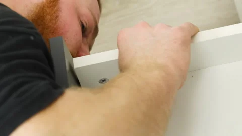 Man works on assembling drawer touching construction Video stock 316188794