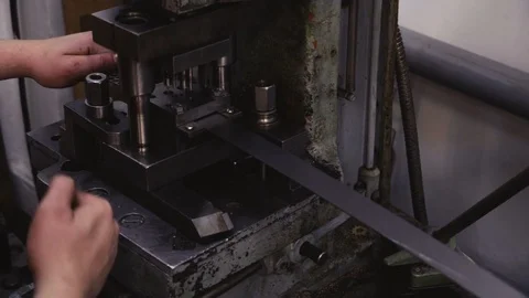 Man works behind a mechanical machine. Makes parts from iron. Stock Footage 116011542