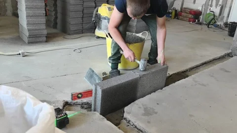 Man works on building project using blocks in construction site during daylight Stock-Footage 332148713