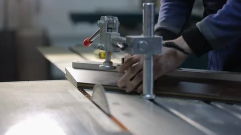 Man works in carpentry workshop, machine with circular saw cuts wooden blank Video stock 128390791