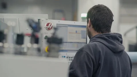 Man works on CNC machine creating components Stock Footage 103335597