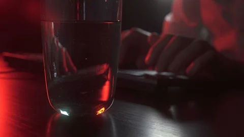 A man works at a computer and drinks water Stock Footage 118935797