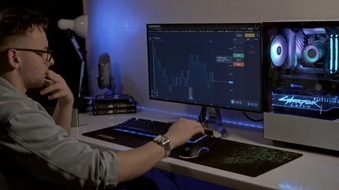 A man works at a computer and looks at his watch. trader works on the stock Stock Footage 127057561