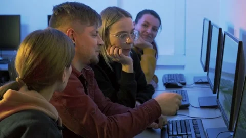 A man works at a computer and teaches students to young women. 4k video. Stock Footage 146664222