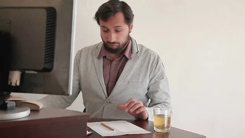The man works on the computer and writes down the result Stock-Footage 75560008