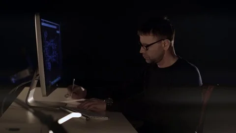 	The man works on the computer. The dark studio. Designer. Constructor. Architec Stock Footage 77676137