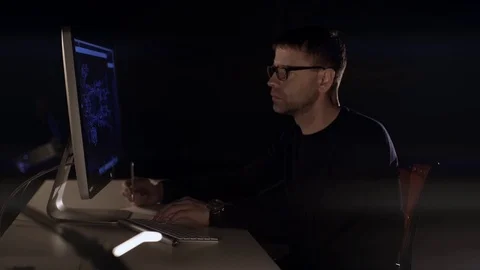	The man works on the computer. The dark studio. Designer. Constructor. Architec Stock Footage 77676686