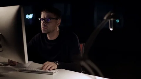 The man works on the computer. The dark studio. Designer. Constructor. Architect Stock Footage 77677249