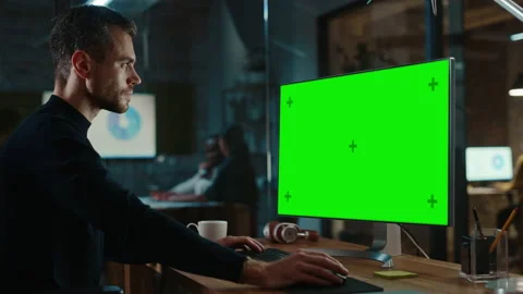 Man Works on Computer with Green Screen in Creative Office Stock Footage 143744960