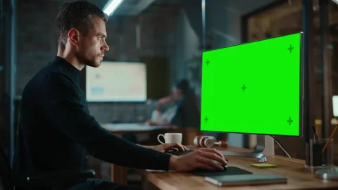 Man Works on Computer with Green Screen in Creative Office Stock Footage 143745024