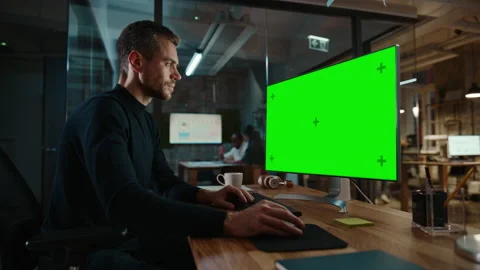 Man Works on Computer with Green Screen in Creative Office Stock Footage 143745066