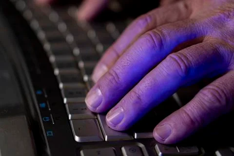 A man works at a computer. Hands of a man on the keyboard close-up. Programmer Stock Photos