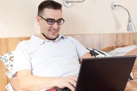 A man works on a computer remotely from home Stock Photos