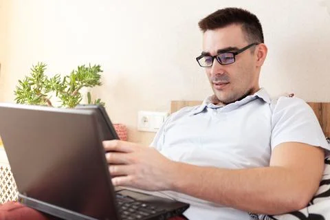 A man works on a computer remotely from home Stock Photos
