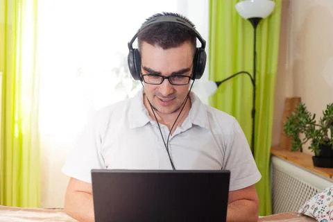 A man works on a computer remotely from home Stock Photos