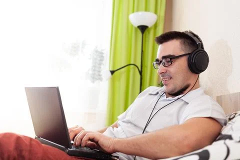 A man works on a computer remotely from home Stock Photos