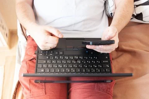 A man works on a computer remotely from home Stock Photos