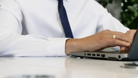 A man works at a computer. sitting at work in a large modern corporate office. Stock Footage 260541213