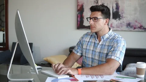 A man works at a computer at work Stock Footage 100577019