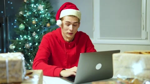 Man works at the computer works during the holiday.worker in santa claus hat Vidéo 164385790