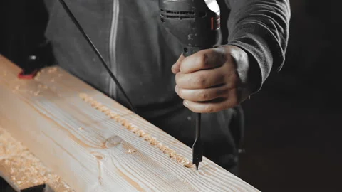 A man works with a drill in his workshop Stock Footage 194682101