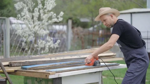 The man works as an electric bank. Processing old boards. Dealing with wood. Stock Footage 130749435