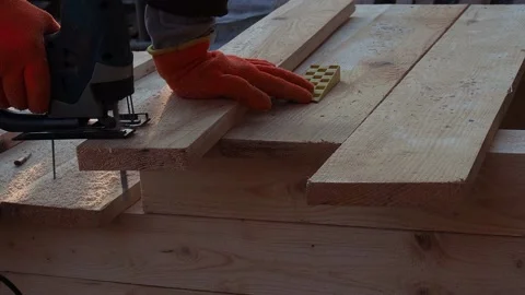 A man works with an electric jigsaw, a worker cuts boards with an electric ji Stock Footage 187157677