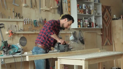 The man works with an electroplane in the carpentry workshop Vidéo 61446368