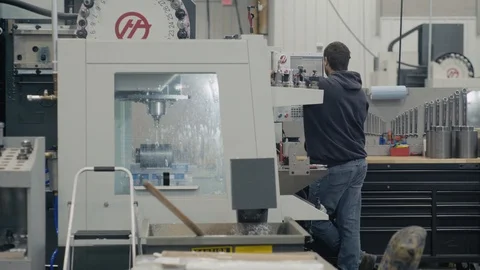 Man works at a HAAS CNC machine creating components Stock Footage 103335526