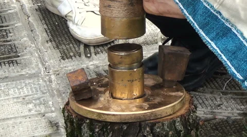Man works hammer minting ancient coin during historical reconstruction amateur Stock Footage 63359997