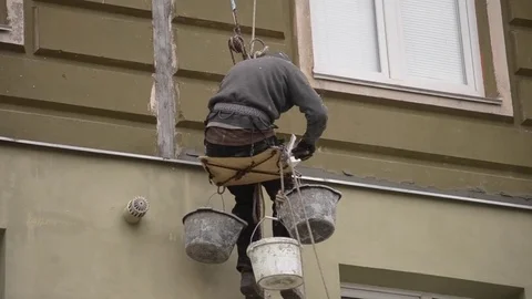 The man works on high-rise works cladding, plastering of the house Video stock 76806853