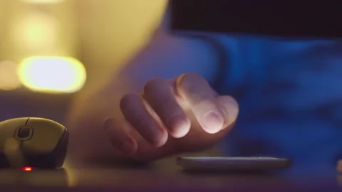 Man works at home on a computer and answers messages on his mobile phone Stock Footage 151217097