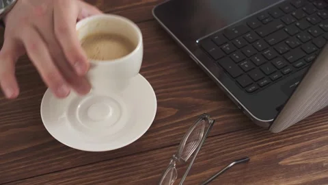 A man works at home using a laptop computer on a wooden table. Portrait of a Stock Footage 154890332
