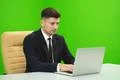 The man works with the laptop on the green background Photo